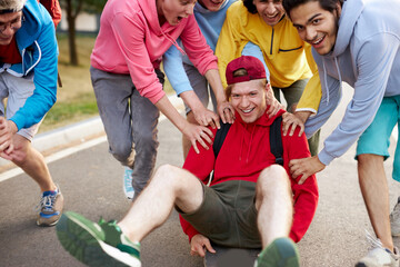 modern friendly guys in casual clothes skateboarding and showing exciting tricks, in the park, city life. extreme sport concept