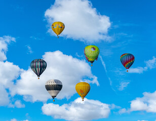 Hot air balloons against a blue cloudy sky