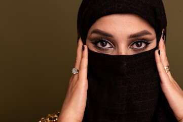 Portrait of beautiful young muslim arabian woman wearing hijab looking at camera, copy space