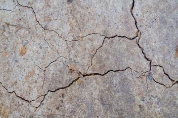 Obraz premium The texture of cracked sandy soil containing small stones
