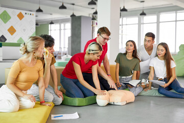 group of young diverse people practice first aid training by hand, first aid course in CPR dummy....
