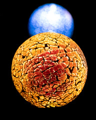 Golden planet with white blue star in deep black space.