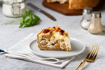 Slice of pie with mushrooms and cheese in a cut on a plate