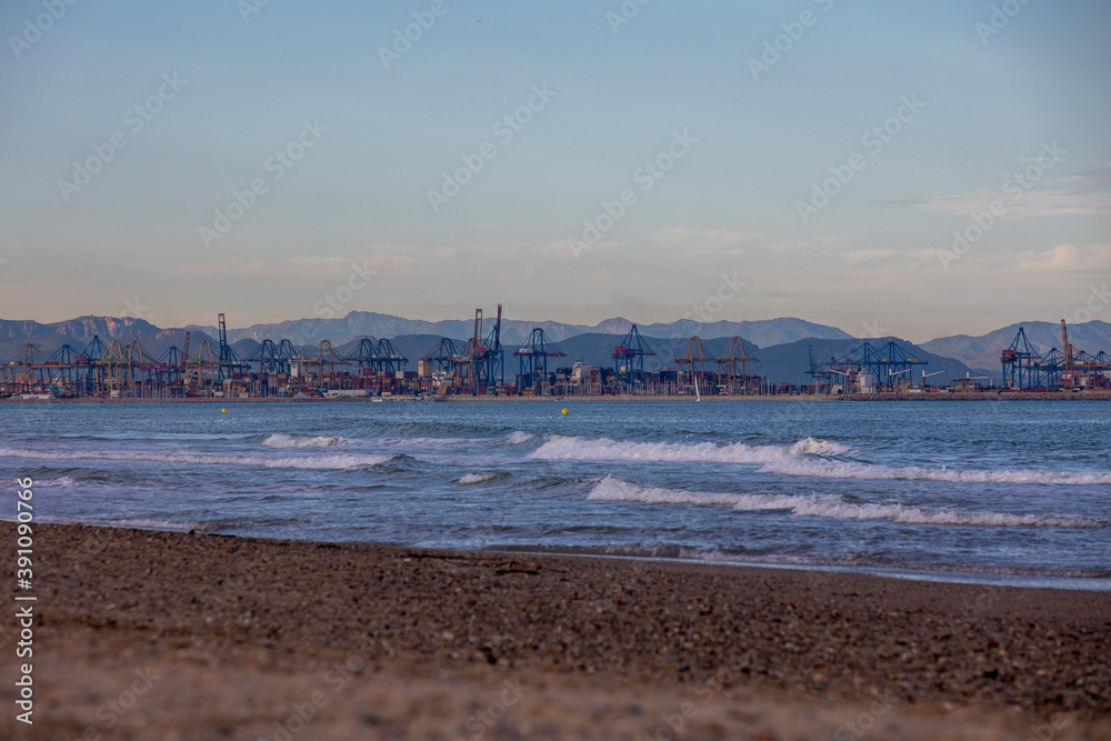 Wall mural cargo port in the distance view from the beach