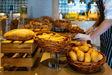 Fototapeta premium cutting board with bread self service table breakfast buffet in hotel catering