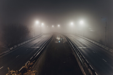 Foggy misty night. Road junction illuminated by street lights