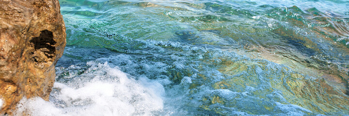 splash of sea water waves near big brown rock on coast aerial view