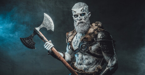 Mystery and evil fashion of northern king of the dead with white skin and hairs holding two handed huge axe in smokey background.