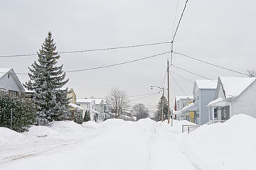 Typical canadian houses with big heaps of snow in front on a cold grey winter day in Gatineau, Quebec, Canada 