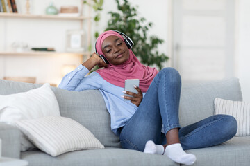Playlist For Relax. Black Islamic Woman Listening Music On Smartphone At Home