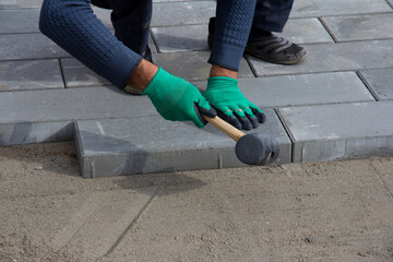 Brick Paver Working. Worker lay paving tiles, construction of brick pavement. Architecture...