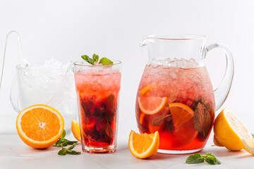 Side view on red berry lemonade in a jug and glass