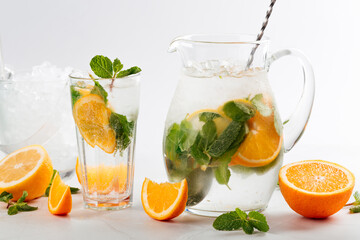Orange and mint lemonade in a jug and glass