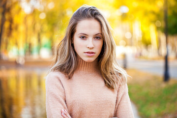 young beautiful blonde girl in beige sweater