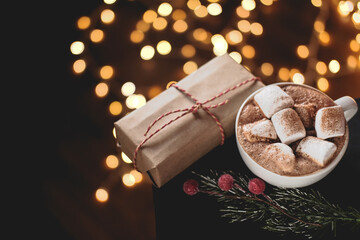 Christmas hot chocolate with added marshmallows and cinnamon, lights bokeh, a sprig of Holly ,pine...