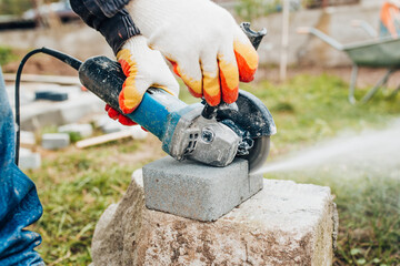 Naklejka premium Fast accurate cutting of concrete stone with a diamond blade on a powerful grinder - trimming paving slabs