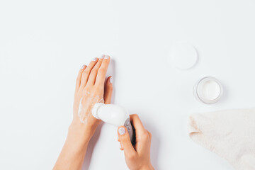 Flat lay woman hands cleansing skin with electric brush