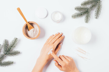 Winter skin care, female hands apply nourishing cream