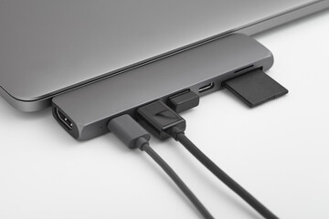 Close-up photo of type-c hub with cables and card connected to laptop