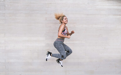 Fototapeta na wymiar Happy young woman wearing sportswear and jump