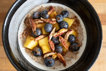 Closeup Oatmeal with Mango, pecans, blueberries
