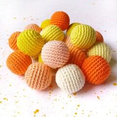 A set of knitted yellow, orange and white beads.