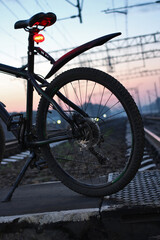 Bicycle on the railway track at sunrise