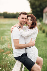 beautiful young couple hugging and having fun outdoors in the park on a warm summer sunny day