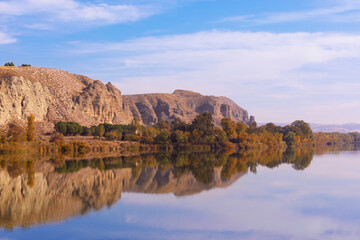 Fototapeta na wymiar Autumn landscape of rocky mountains over the water of a lagoon