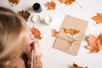 autumn craft for kids. animal Fox made from maple leaf. childrens art and creative. handicraft made from natural materials. girl draws with paints