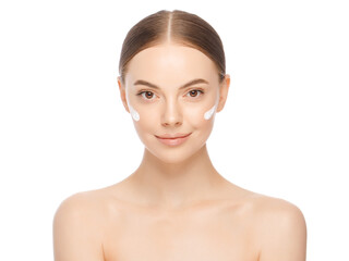 Young woman with face cream applied on cheeks and perfect skin, isolated on white background