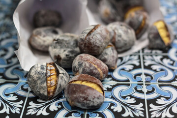 Roasted chestnuts on Portuguese tiles background