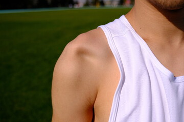 sportsman with shoulder dislocation in turf/sports field. shoulder bone is clarified.  - obrazy, fototapety, plakaty