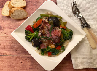 Mediterranean grilled vegetable platter with raw ham, zucchini, tomatoes, broccoli, onions, mushrooms, bell pepper, herbs and balsamic vinaigrette.