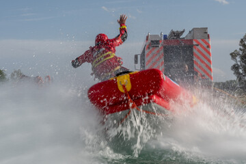firefighters in water rescue drill, using canoe and special suits.