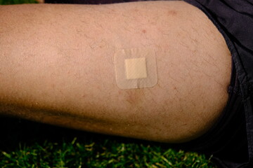 apply a plaster to the wound on the leg. wound care. first aid after a sports injury.