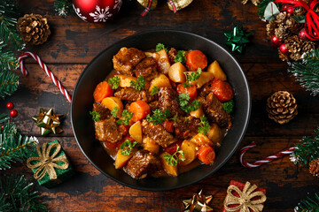 Christmas Beef Stew with decoration, gifts, green tree branch on wooden rustic table