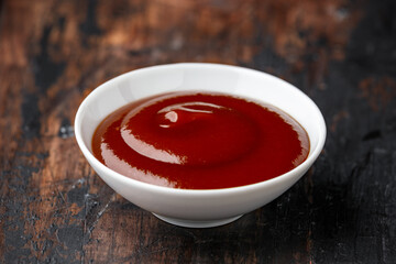 Barbecue sauce in white bowl on wooden table