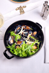 Mussels in a saucepan on a table.