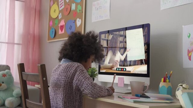 Cute smart african primary school kid girl distance learning by video conference call chat with remote teacher, online tutor teaching digital class, web lesson on computer at home. Virtual education.