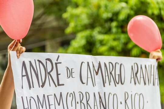 M&atilde;os de duas pessoas segurando cartaz com bal&otilde;es vermelhos. Imagem feita durante uma manifesta&ccedil;&atilde;o em Goi&acirc;nia, em apoio &agrave; Mari Ferrer, uma jovem brasileira que sofreu viol&ecirc;ncia sexual em uma festa.
