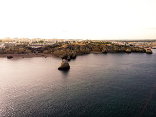 Rocky sandy bay among cliffs on a sunset