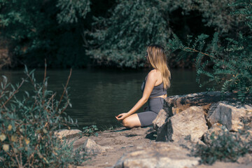 Fototapeta premium Girl does yoga by the river