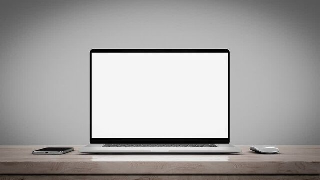 Laptop with blank screen on table smooth zoom in with mouse and smartphone. Gray background, luma matte included for easy replacing background 4k 30fps UHD