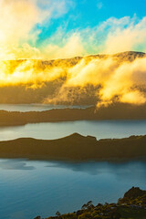 Shining clouds at sunrise at a fjord in New Zealand