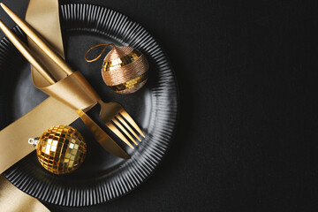 Obraz na płótnie Canvas Golden cutlery on plate with bauble