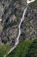 Fototapeta na wymiar Water falls down mountains in Glacier National Park.