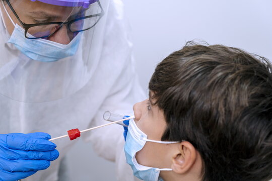 A nurse takes a nasal swab from a patient