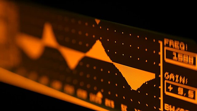 The professional concert parametric equalizer has a yellow spectrum analyzer on the display that analyzes the frequency range of music or any sound and can change it. Closeup