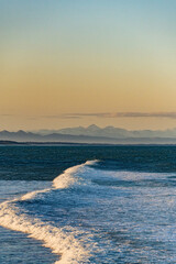 Sunset with waves at the beach in New Zealand